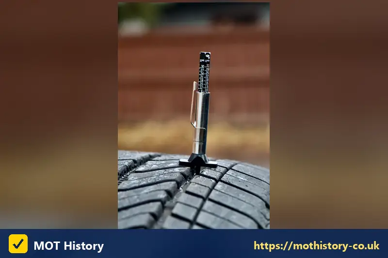 Tyre tread depth gauge standing in a tyre groove - check mot history northern ireland