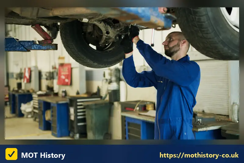 Mechanic inspecting the underside of a car on a lift - dca claims