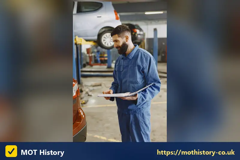 Mechanic holding a clipboard in a garage bay - news car tax