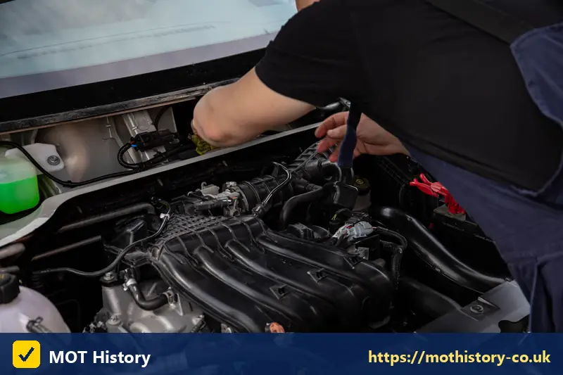 Close view of a mechanic working on a petrol engine - penalty for driving without mot