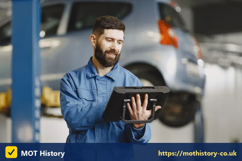 Vehicle inspector holding a tablet in a garage - phone car tax number