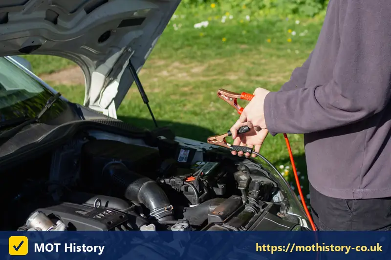 Jump leads clipped to a car battery under the bonnet - pre mot test