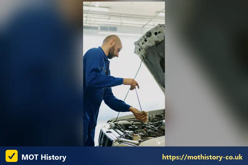 Mechanic checking the oil level with a dipstick - pre mot test
