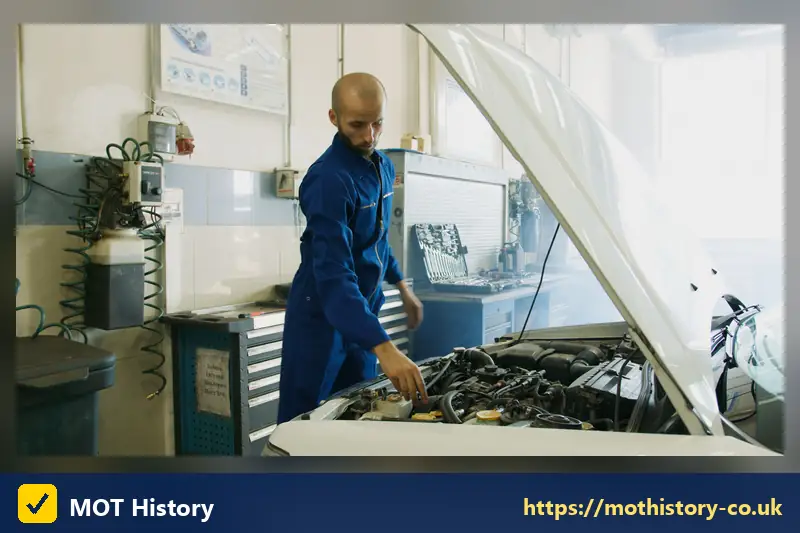 Mechanic examining an engine under a raised bonnet in a workshop - sorn my vehicle online