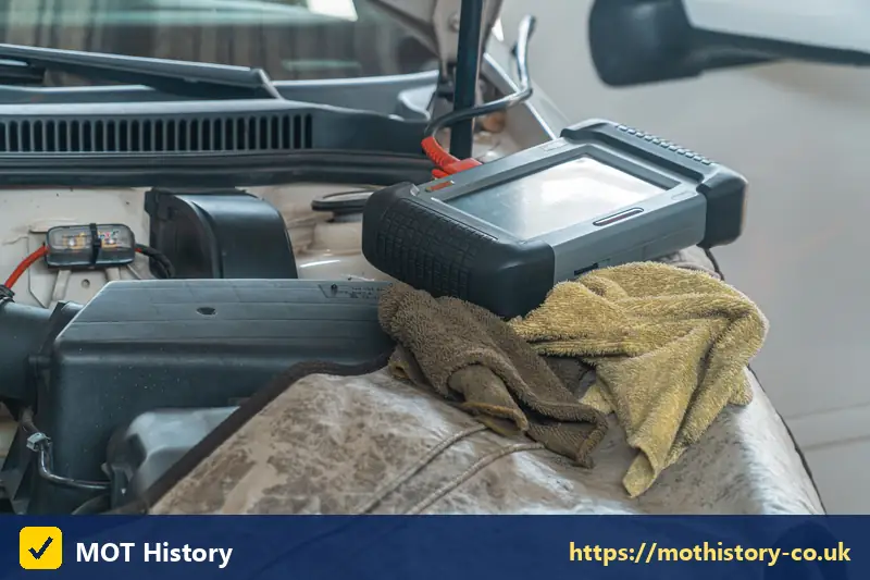 Diagnostic tablet resting on a car engine - trade plate check