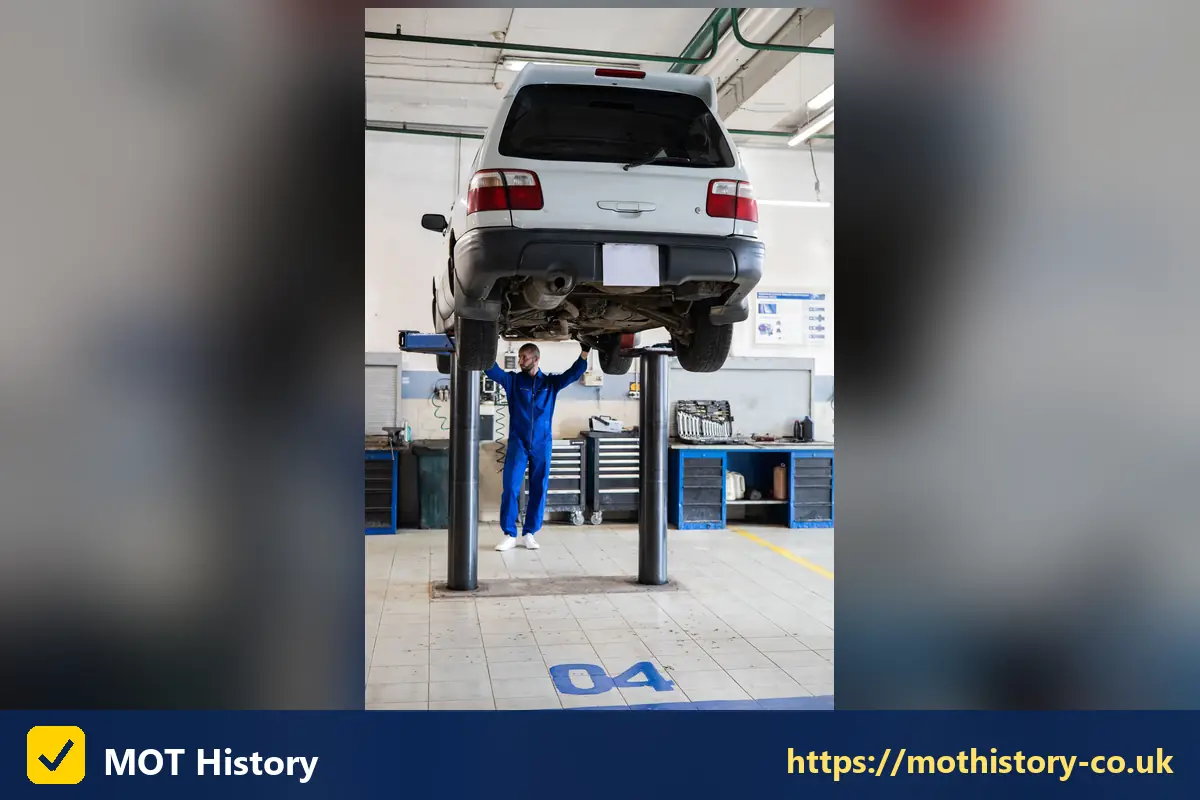 Car raised on a lift with a mechanic standing beneath it - can i mot my car 3 months early