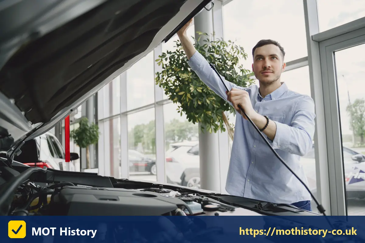 Man checking under the bonnet of a car in a showroom - how to check if a car has been scrapped