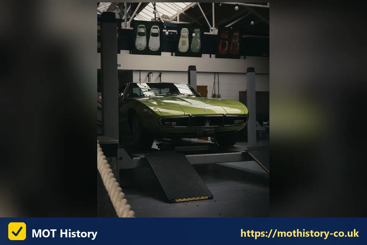 Classic green sports car raised on a garage ramp - sorn my car